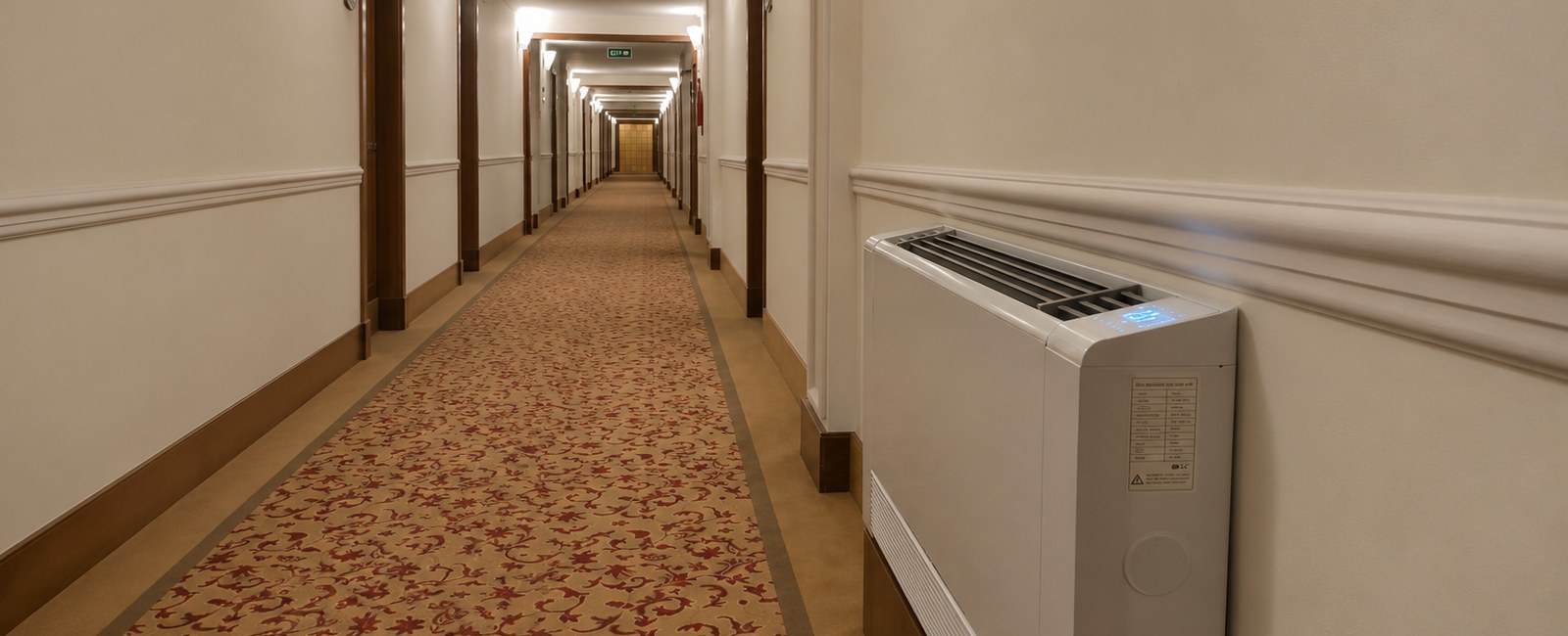 Hotel corridor vertical fan coil installation showing exposed floor-standing architecture and access