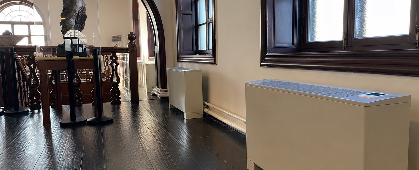 Public museum interior with floor-standing vertical fan coil for environment and investment considerations